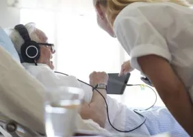 L'infirmière Léa, aide son patient Pierre sur son mobile.