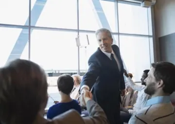 Bernard, nouvel élu, serre la main d'un administré.
