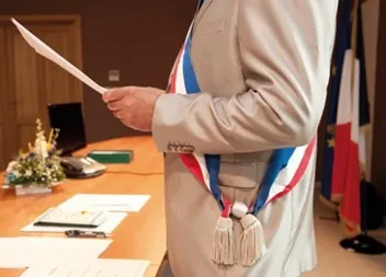 Visuel d'un maire élu avec son écharpe tricolore.