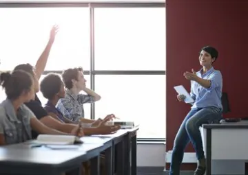 L'enseignante Emilie interroge ses élèves en classe.