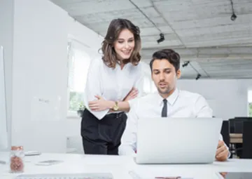 Dos analistas trabajan en el ordenador gracias a un software de gestión.